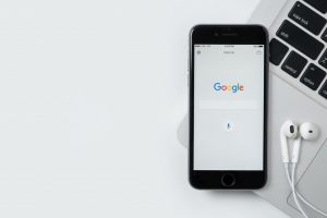 iPhone showing Google search screen on top of laptop keyboard