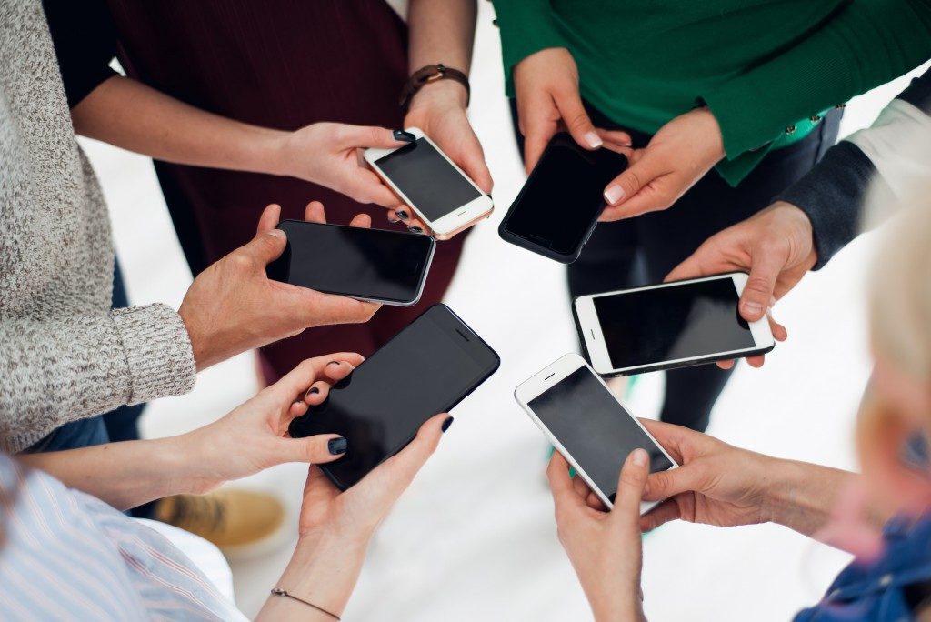 colleagues using their smartphones in a huddle