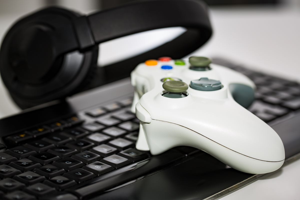 video game controller on a keyboard and a pair of headset
