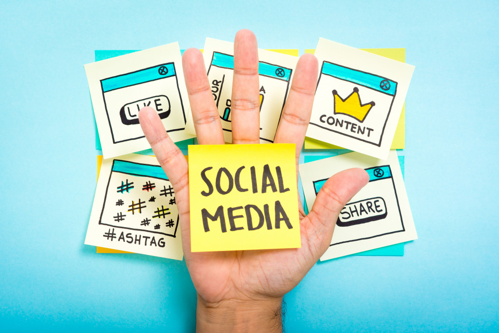 hand holding note with social media written and other SMM post its
