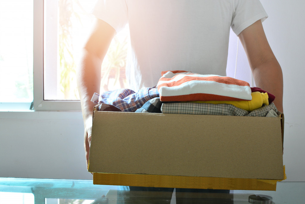 clothes in box carried by man concept of donation