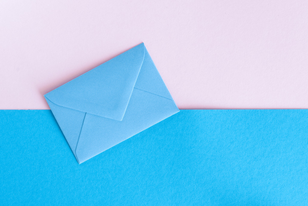 A blue envelop on pink and blue background